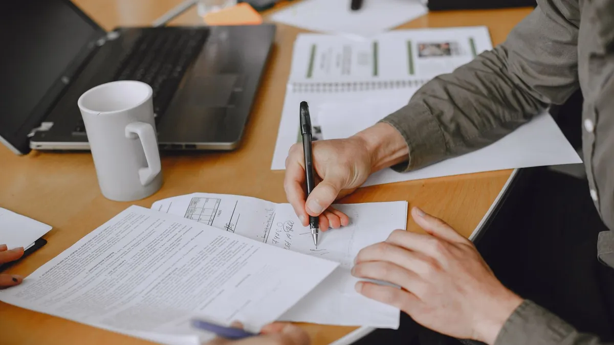 Hands signing a guaranteed installment loans agreement on a laptop