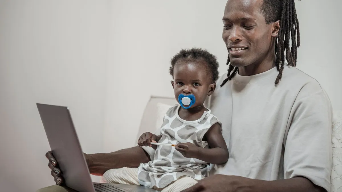 Parent and child at home using a laptop to compare installment loan payments