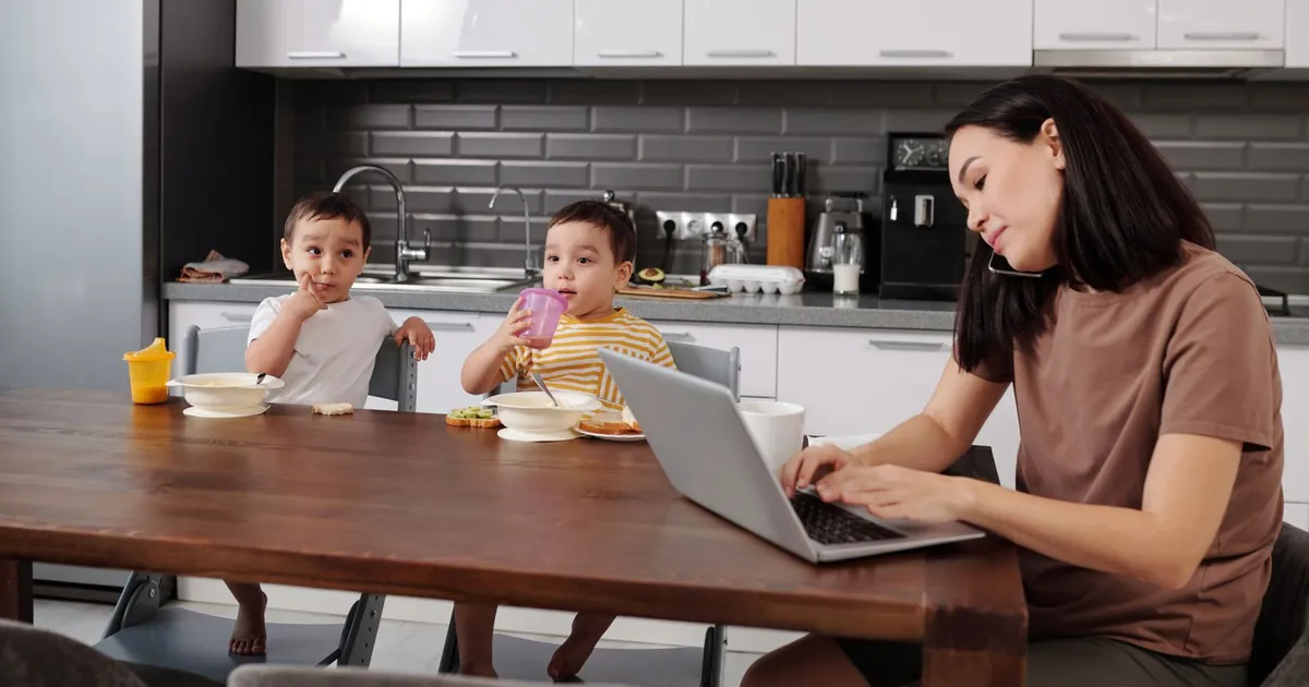 Family at a kitchen table reviewing installment loans on benefits on a laptop